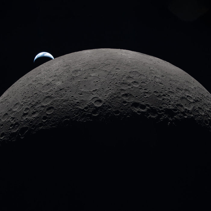 The Moon's curved limb with Orientale basin and Hertzsprung Basin visible, Earth setting on the horizon, photographed by Artemis II