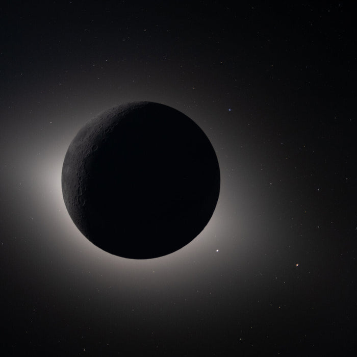 The Moon fully eclipsing the Sun as photographed by the Artemis II crew during their 2026 lunar flyby, with a glowing halo and background stars visible