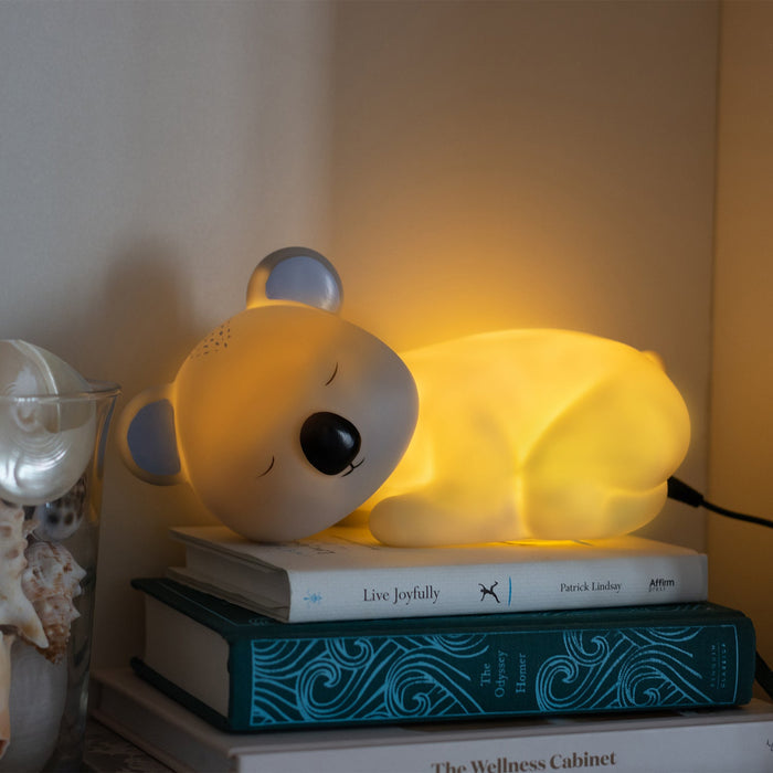 Sleeping Koala-shaped blue night light. These newest Night Lights are set to be an incredible décor addition to any little ones' room and an amazing gift idea for all occasions - birthdays, christenings, holidays, and just because! Boasting a collection of creatures that are sure to both delight and soothe kids of all ages, Night Lights come with custom packaging that features a fun poem and are powered by a USB cord to ensure the Night Light stays bright.